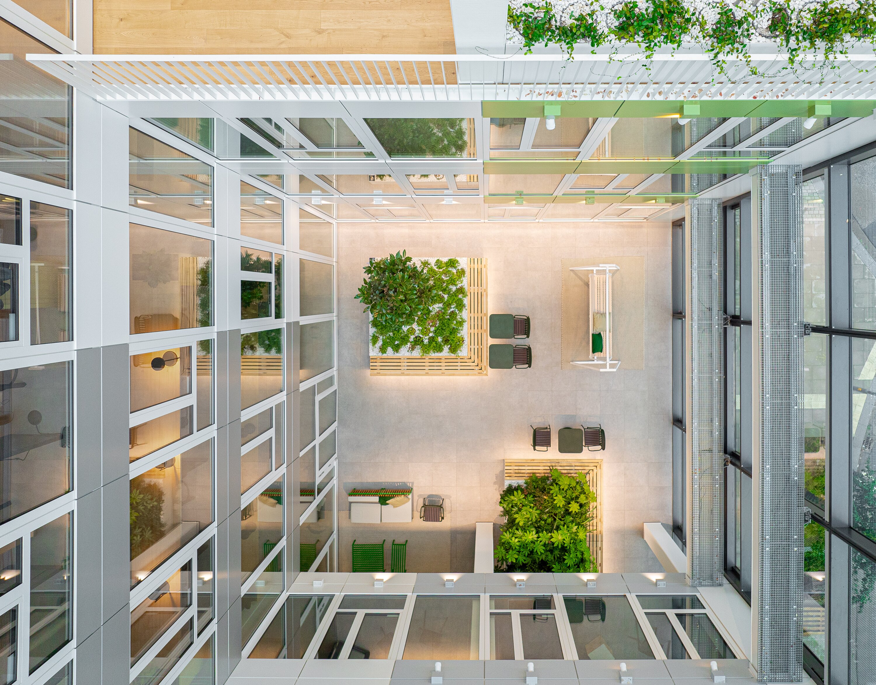 Project by Behnisch Architekturbuero, EDGE ElbSide Hamburg. Light-filled atrium with seating areas and planting.