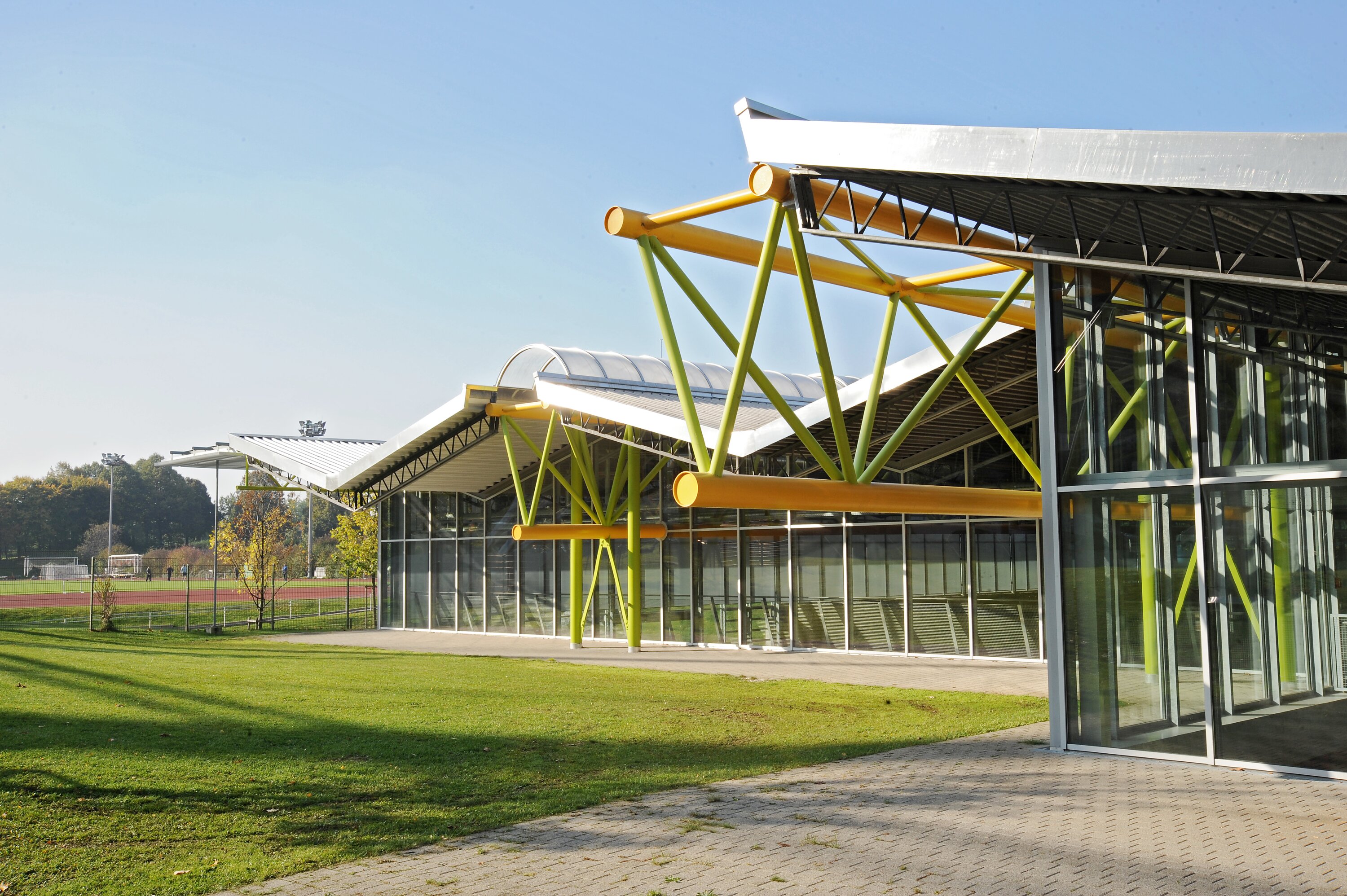 Project by Behnisch Architekturbuero, Thermal Roemerbad. Indoor spa area with pool, lounge chairs, and large windows overlooking a green hillside landscape.