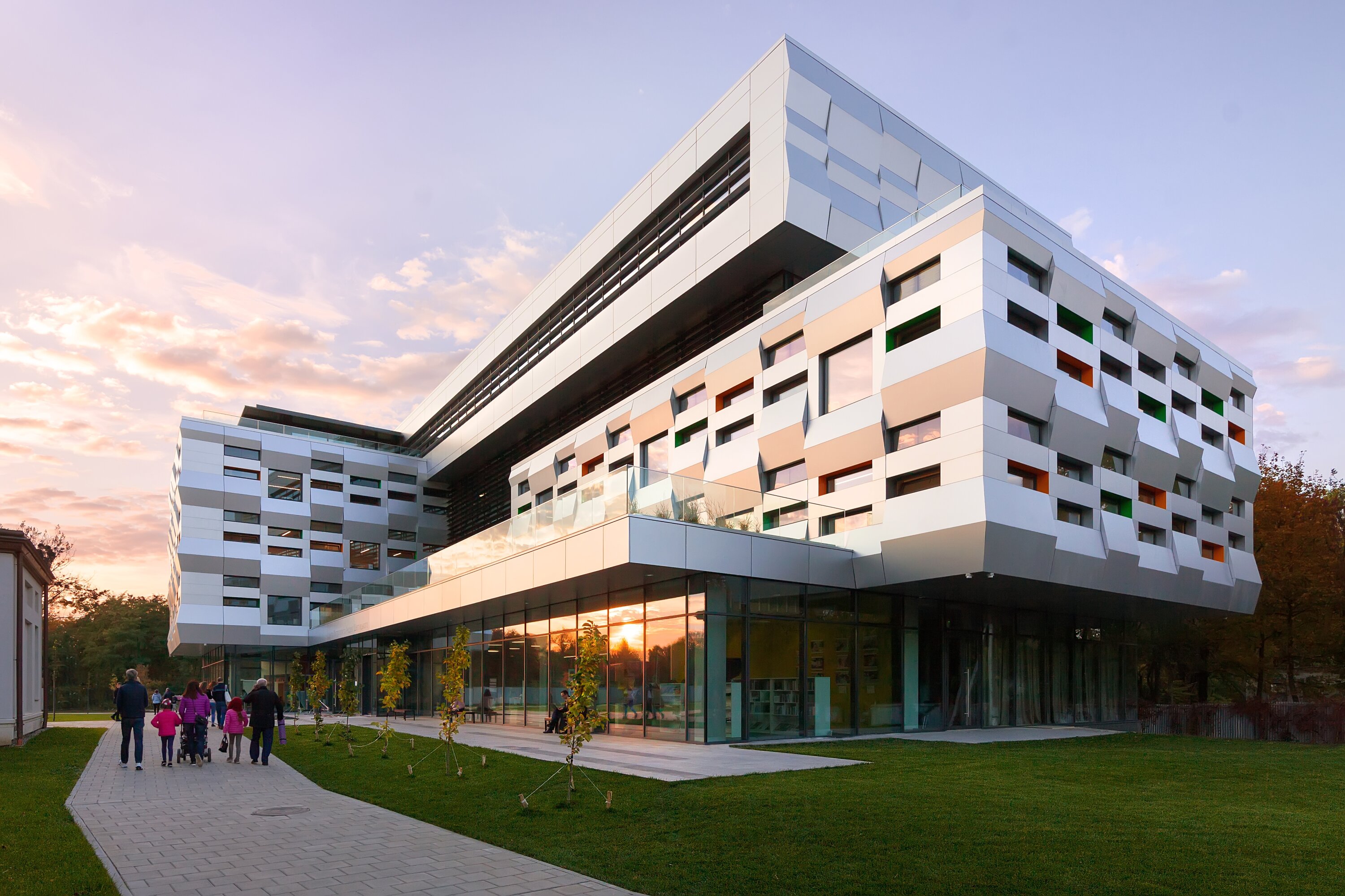 Project by Behnisch Architekturbuero, Karl Miller Center. Open study area with bright yellow walls and grenn acusticceiling. Students are working at tables and a central counter.