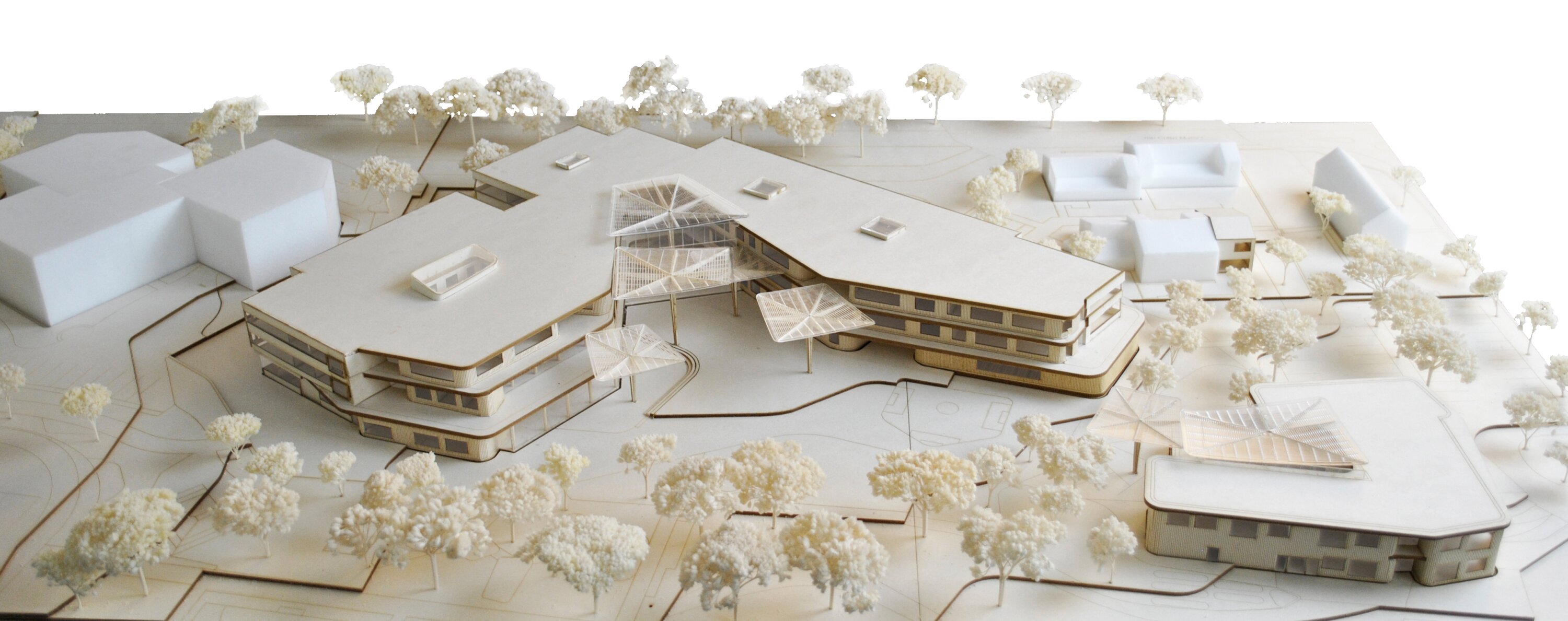 Project by Behnisch Architekturbuero, Lycee Franco Allemand. Architectural model of the school complex with multiple connected buildings, trees, and canopy structures arranged across a landscaped site.